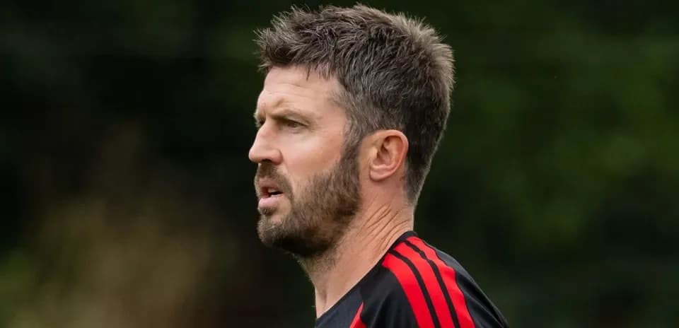 Man with short hair wearing a black and red training top