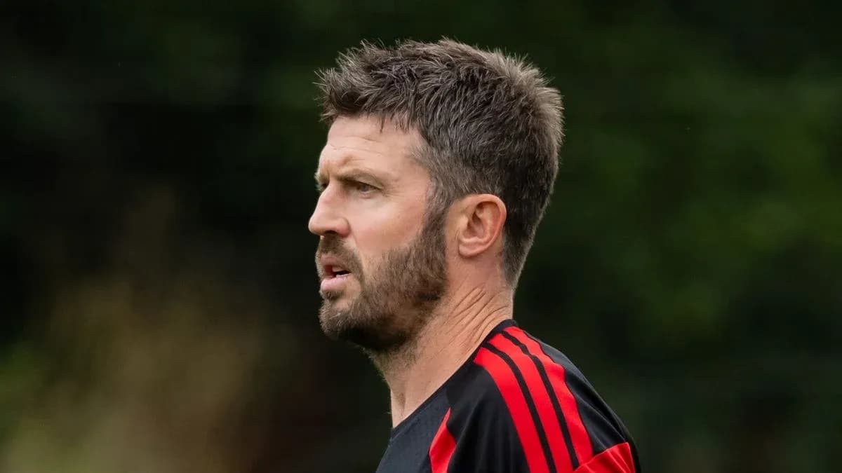 Man with short hair wearing a black and red training top