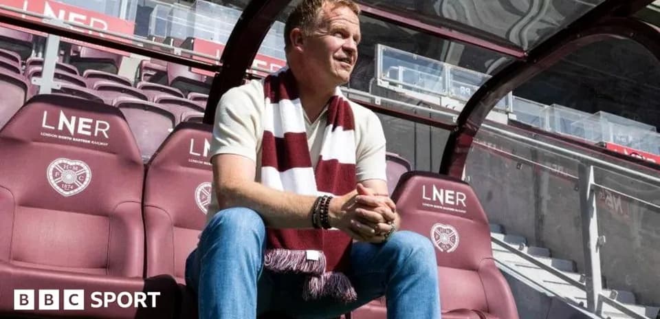 Manager seated in dugout at football stadium