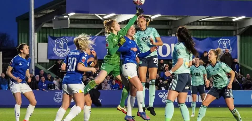 Goalkeeper leaps to catch the ball during match