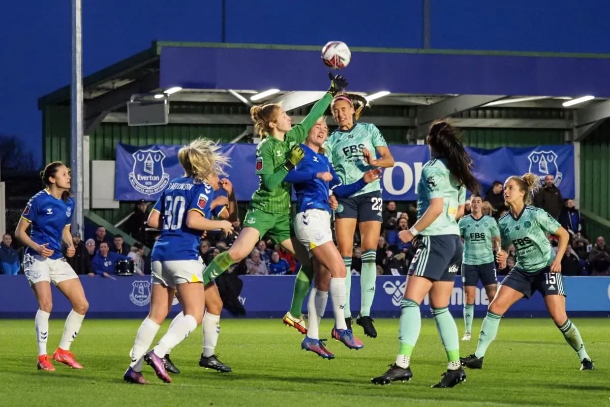 Goalkeeper leaps to catch the ball during match