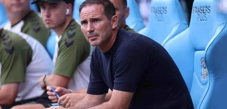 Manager sitting on bench during a match