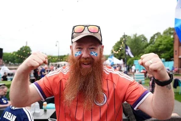 Supporter celebrating with Scotland face paint and jersey
