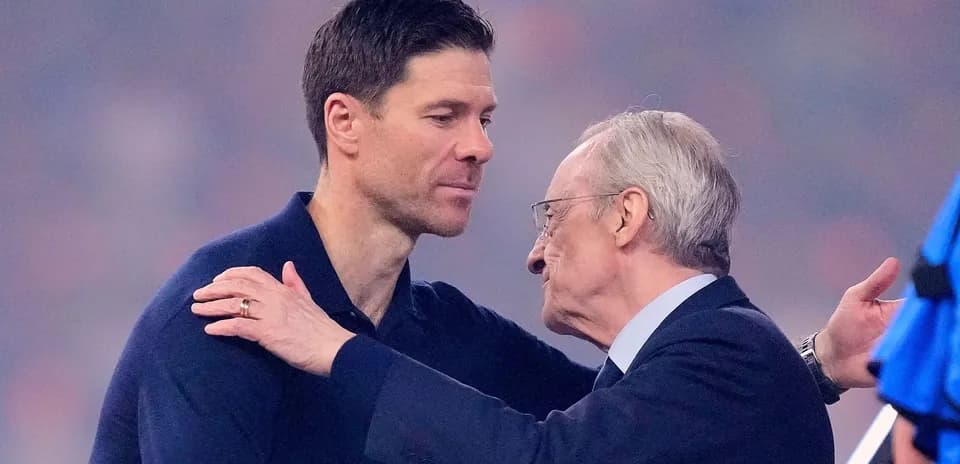 Two men embracing on a football pitch