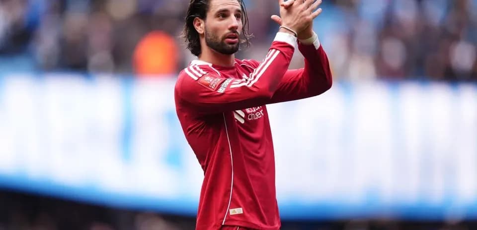 Player applauding fans in red team jersey