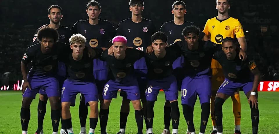 Football team posing for group photo on pitch