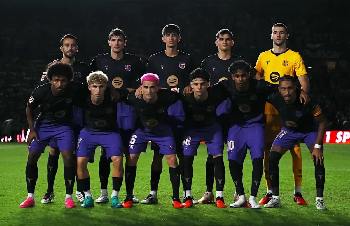 Football team posing for group photo on pitch