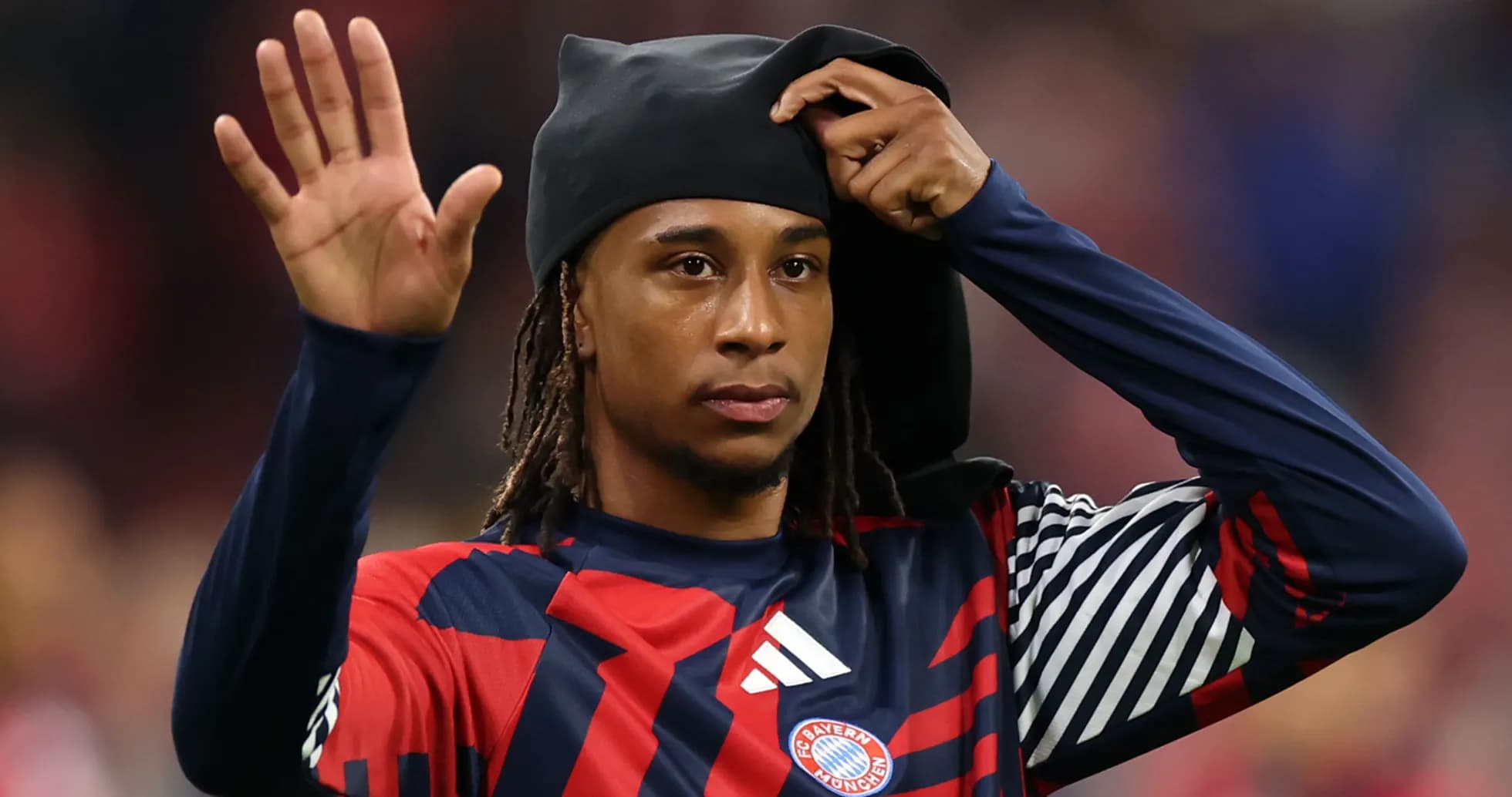 Player waving while adjusting his headwear