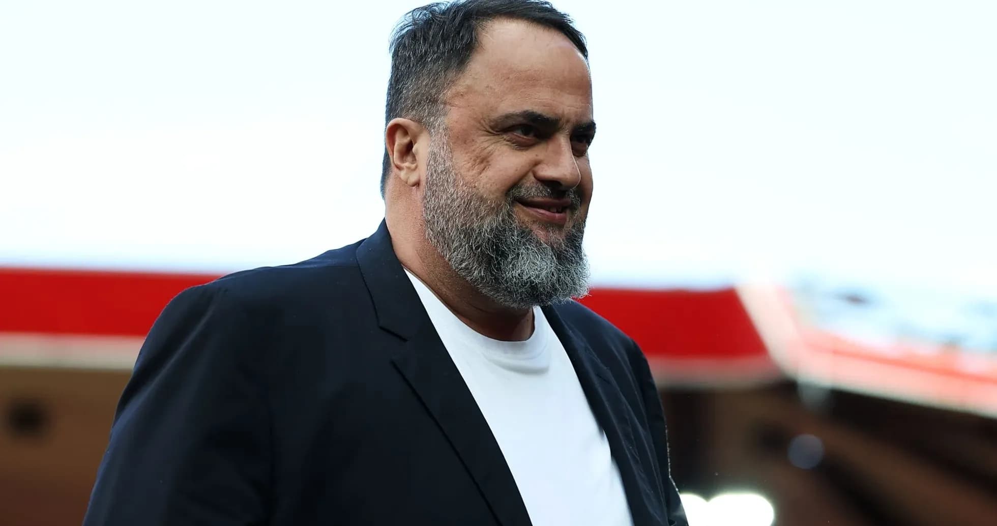 Man in black suit walking at stadium entrance