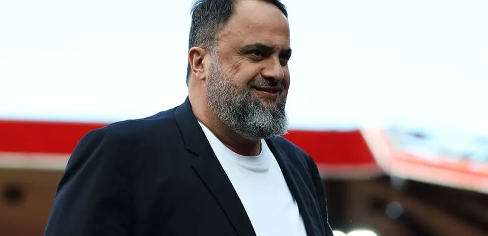 Man in black suit walking at stadium entrance