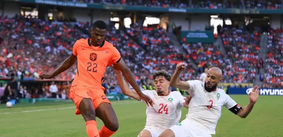 Player 22 of Netherlands evades two defenders during match