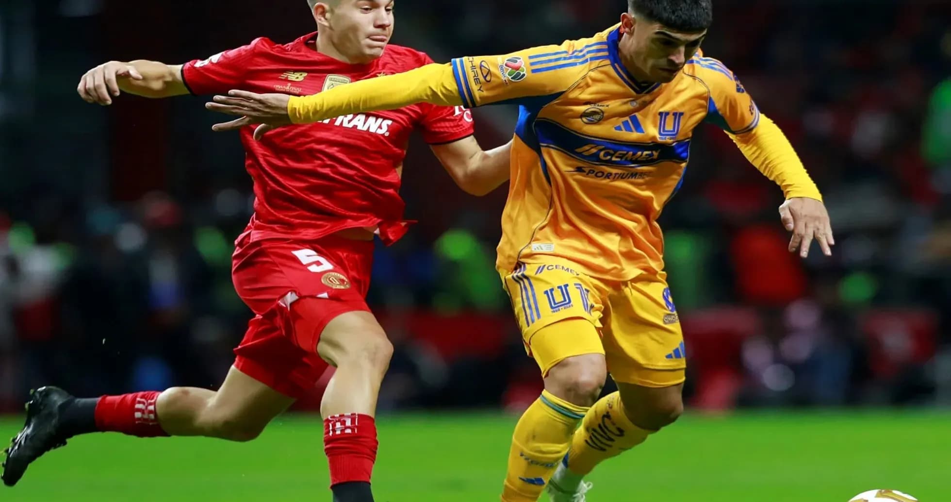Toluca player challenges Tigres UANL player for ball