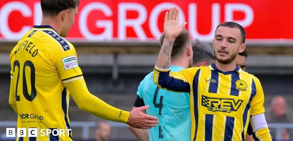 Two players exchanging high-fives on the pitch