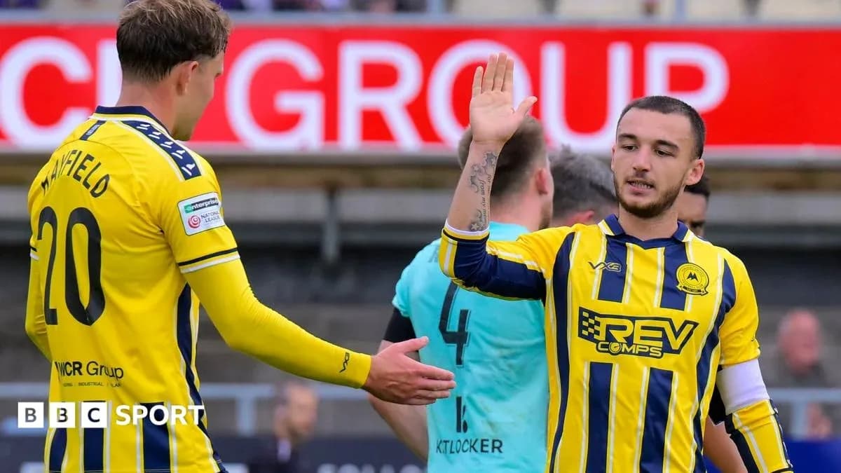 Two players exchanging high-fives on the pitch