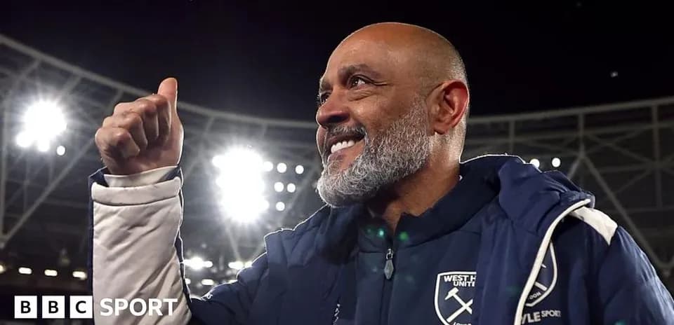Manager celebrating with a thumbs up in stadium