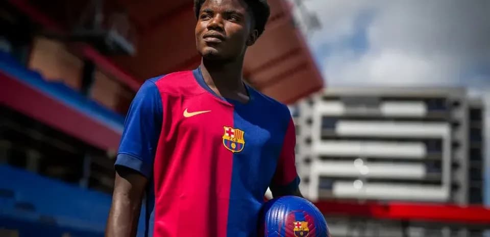 Player posing with a football at stadium