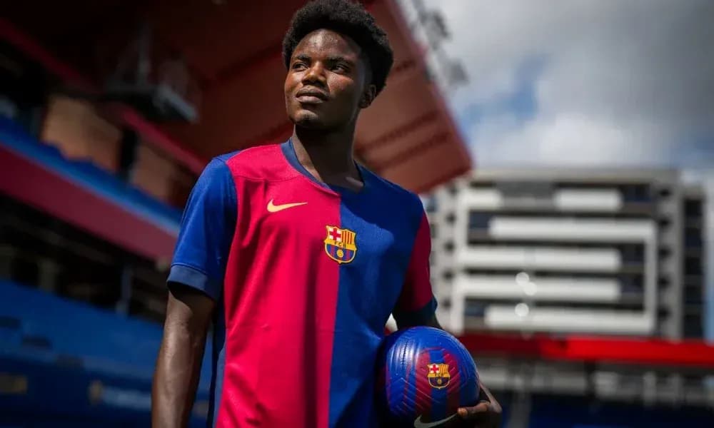 Player posing with a football at stadium