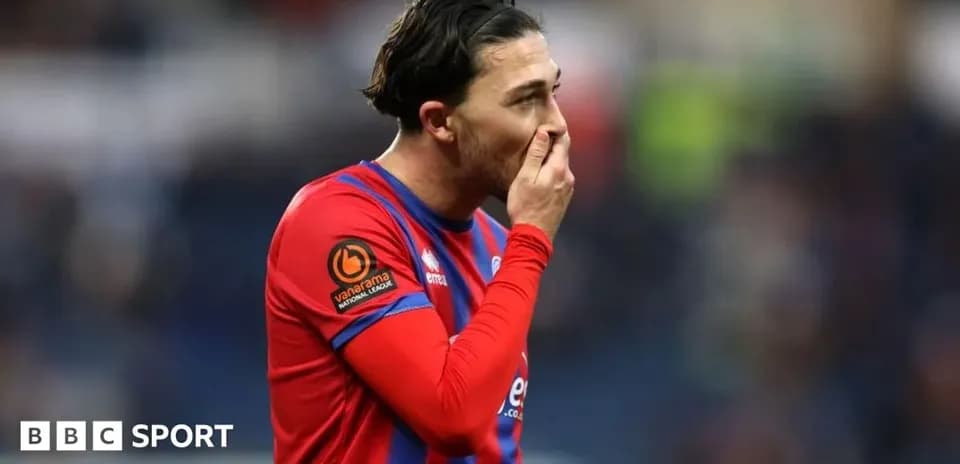 Player in red jersey looking pensive during match