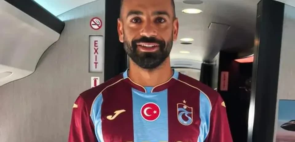 Player wearing Trabzonspor jersey in airplane cabin