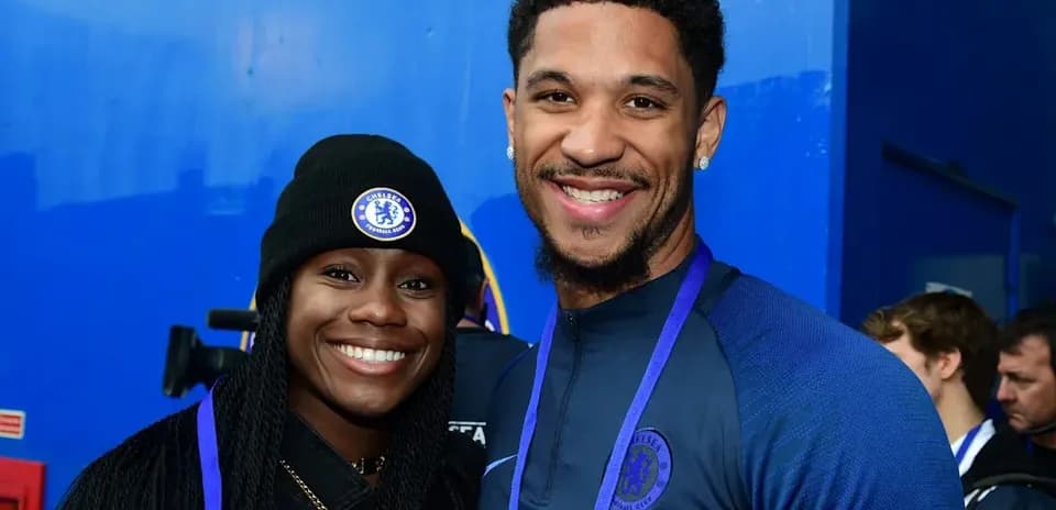 Two individuals posing in Chelsea FC attire