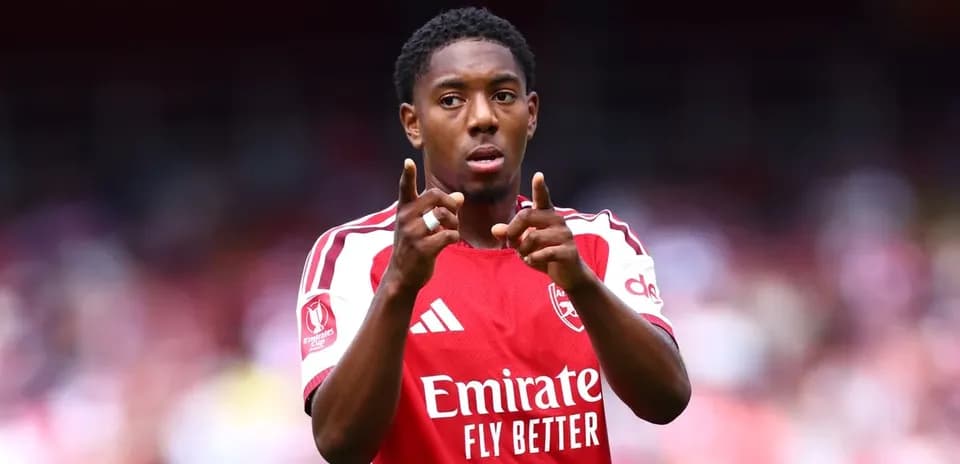 Player gesturing during match wearing Arsenal jersey