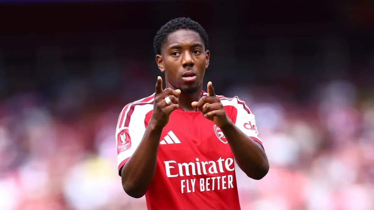 Player gesturing during match wearing Arsenal jersey
