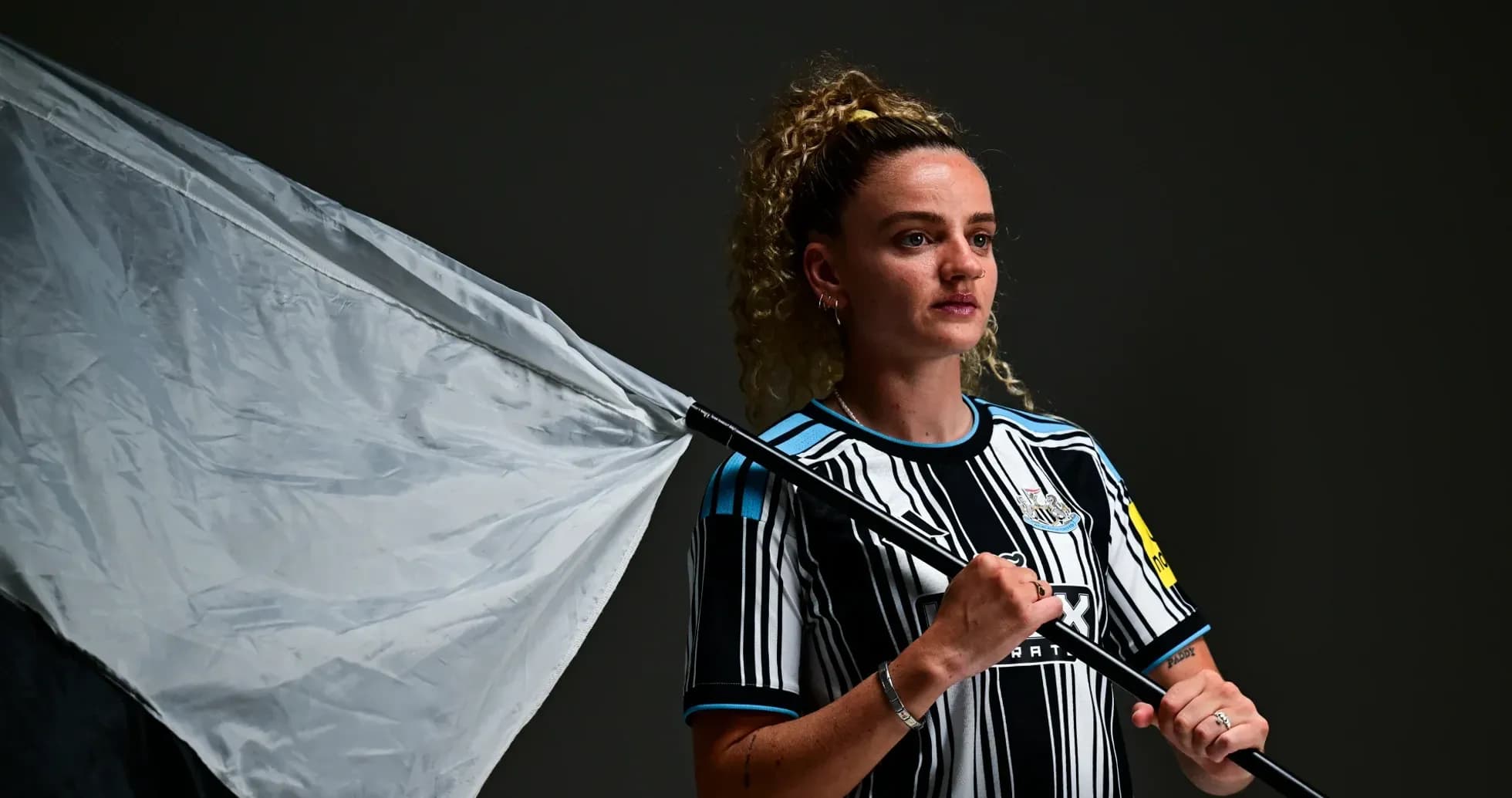 Player holding a flag wearing Newcastle United kit