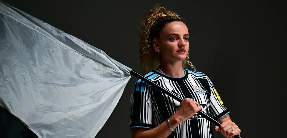 Player holding a flag wearing Newcastle United kit