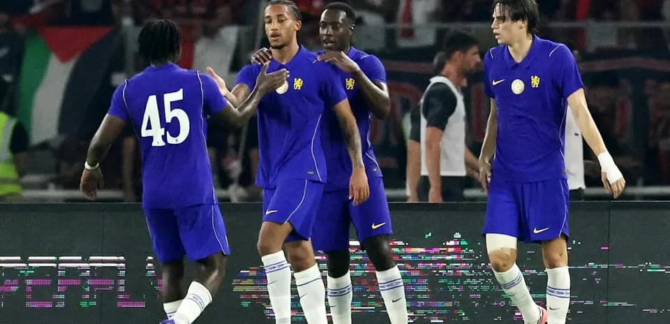 Four players celebrating on the field during match