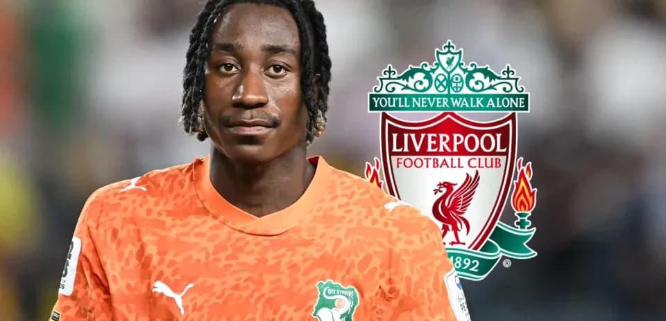 Player in orange jersey with Liverpool logo backdrop