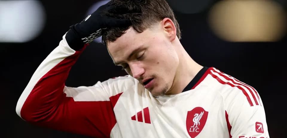 Player in Liverpool jersey looking down with concern