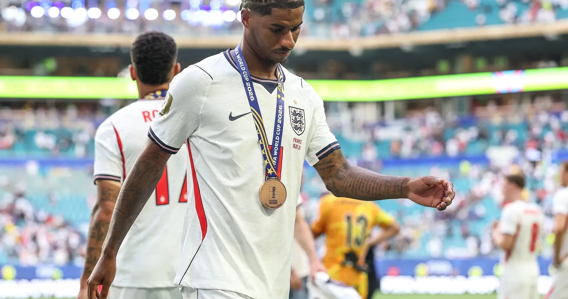 Player walking off field wearing a medal