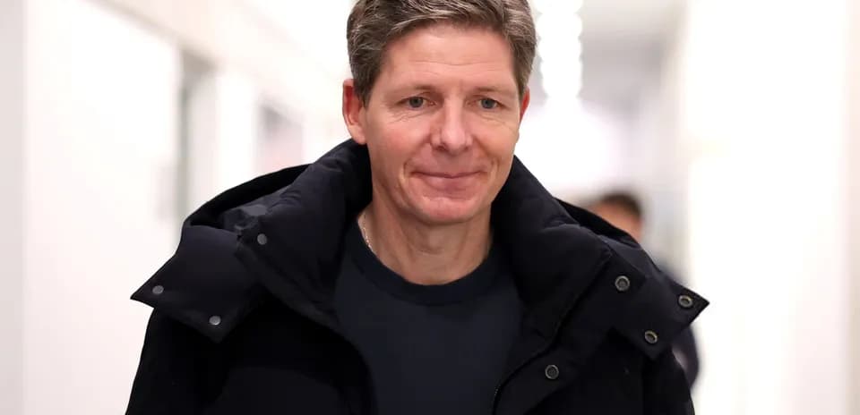 Person walking in a corridor wearing a black coat