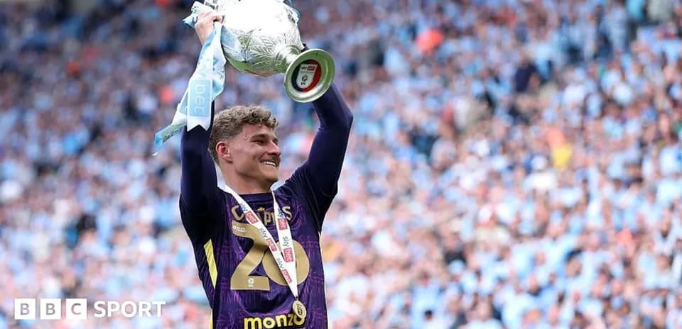 Goalkeeper lifting trophy in celebration after match
