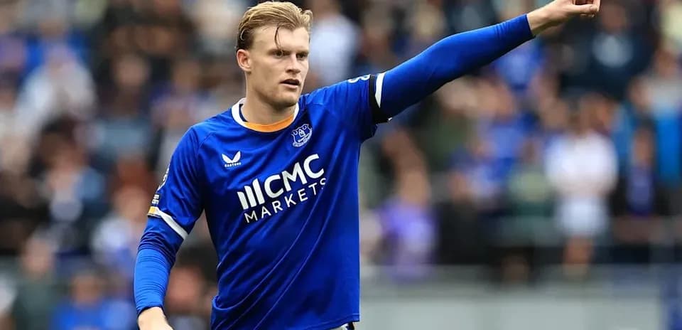 Player in blue jersey gesturing on the field