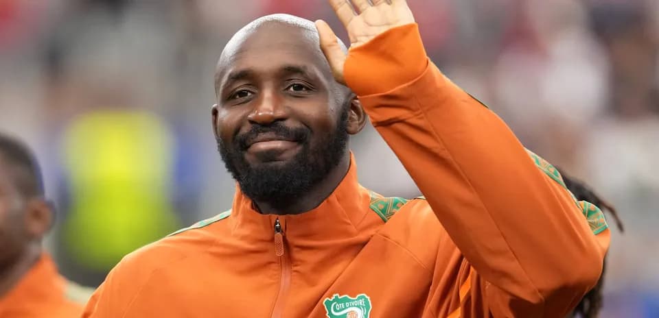 Player waving while wearing Ivory Coast training jacket