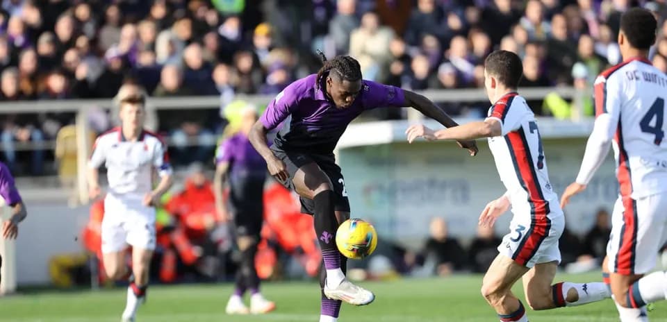 Fiorentina player dribbling against Genoa defenders