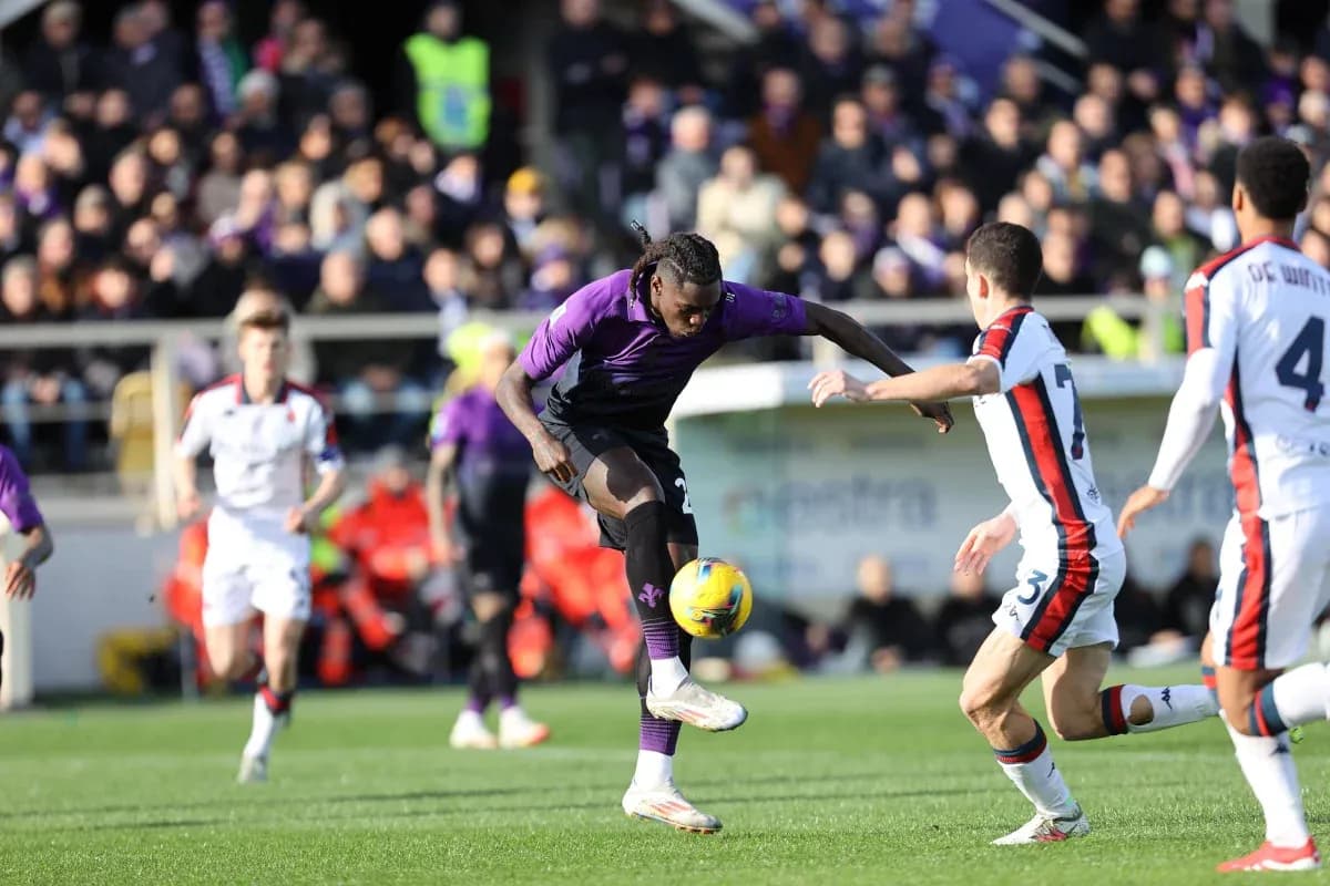 Fiorentina player dribbling against Genoa defenders