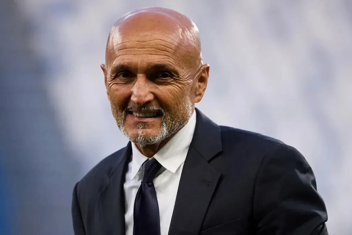 Coach smiling while wearing a suit at stadium