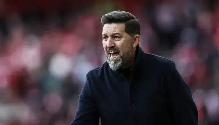 Manager gesturing passionately during match