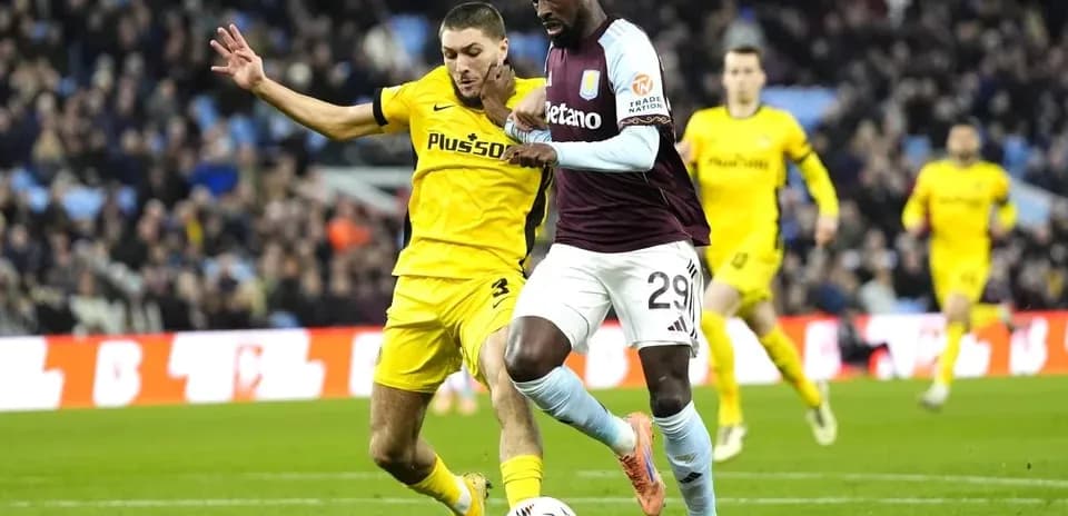 Player dribbling ball while being challenged by opponent