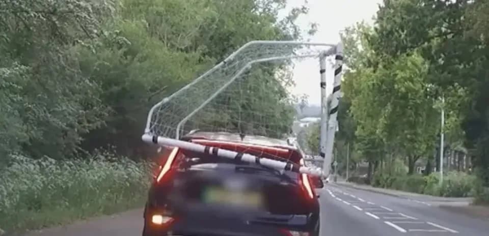 Car transporting a soccer goal on the roof