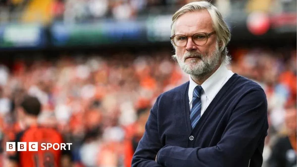 Coach observing match with arms crossed on sidelines