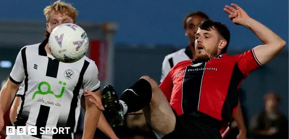 Player in red kicking ball during match action