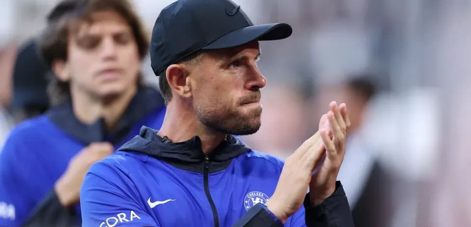 Coach applauding during match with players behind