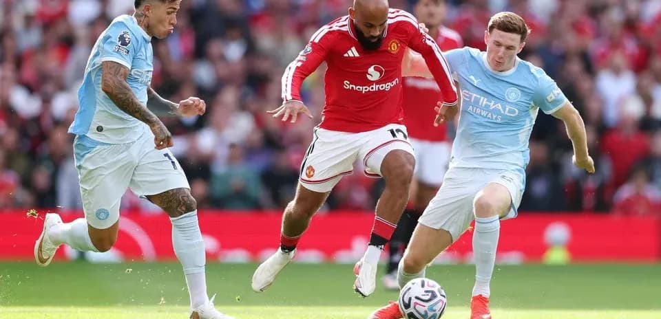 Manchester United and Manchester City players competing for the ball