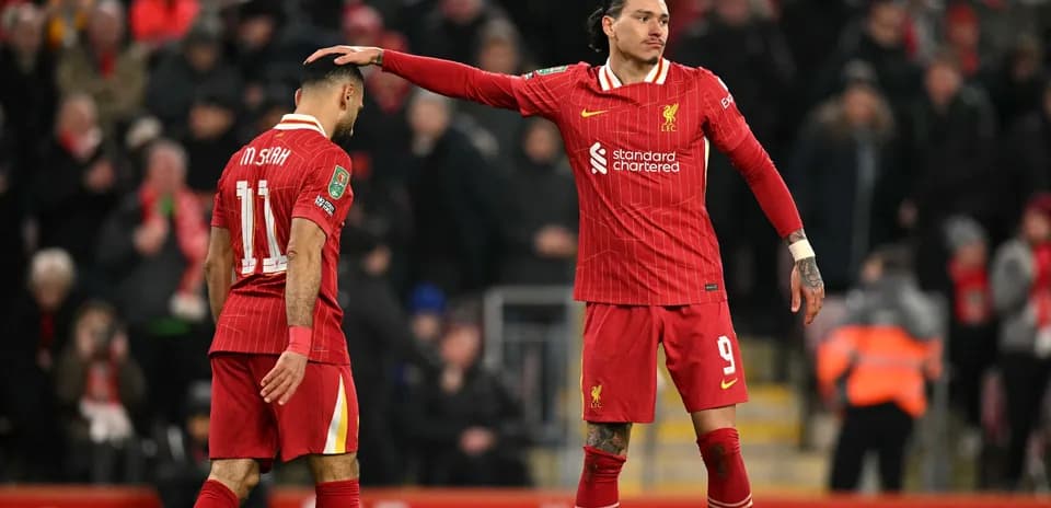 Two Liverpool players on the pitch after a match