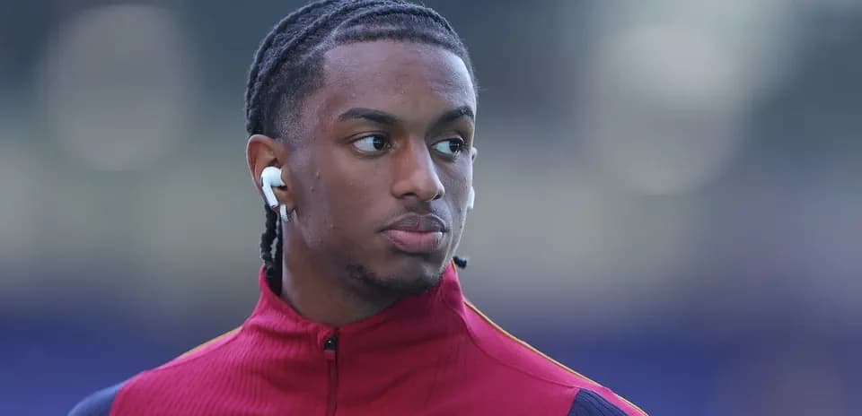 Player wearing earbuds in red training jacket