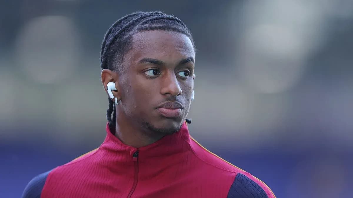 Player wearing earbuds in red training jacket