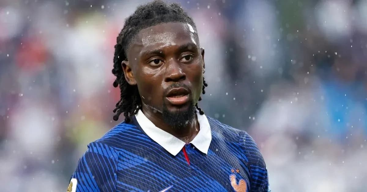 Football player in blue jersey during rainy match